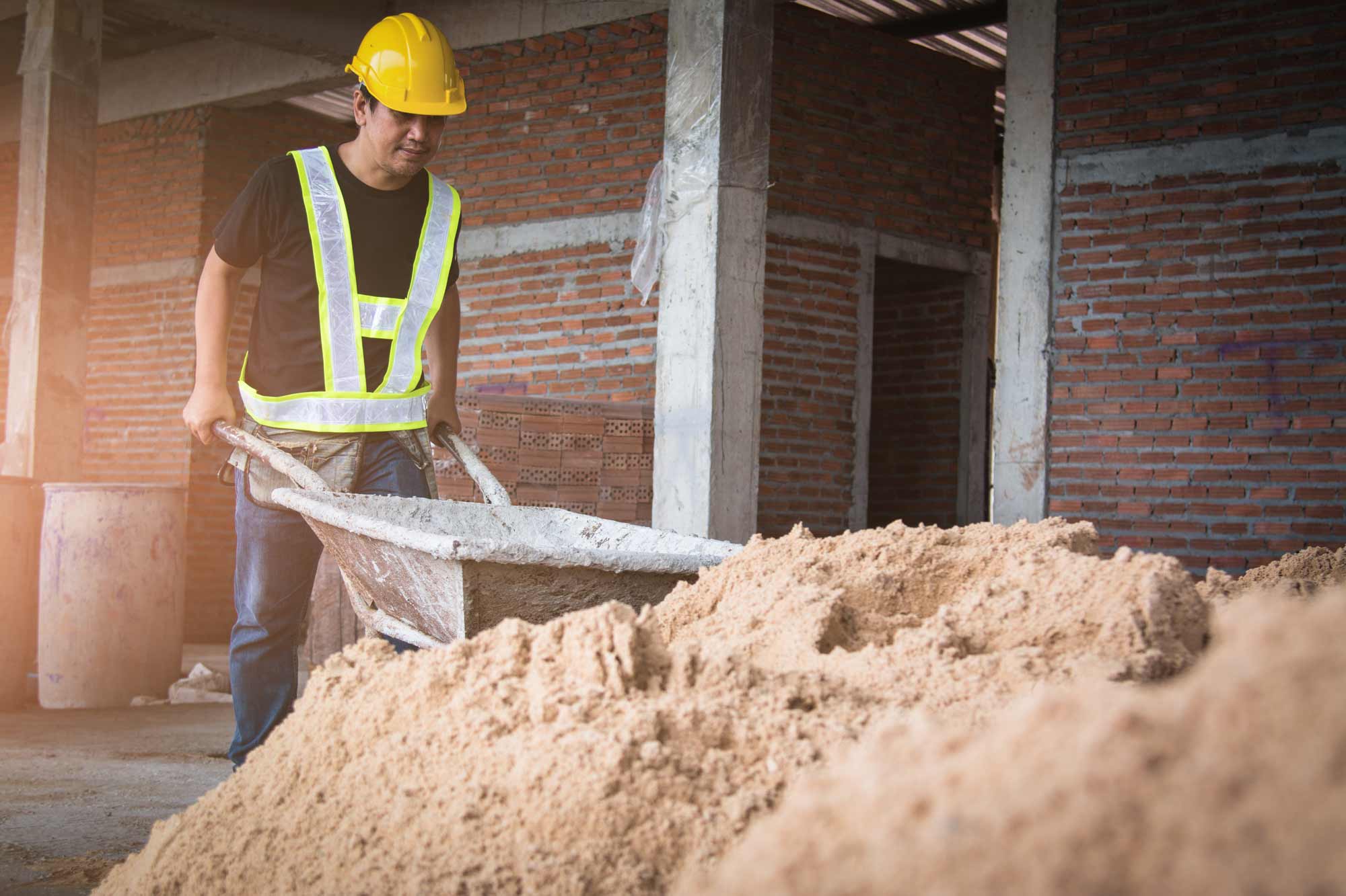 construction worker picking up materials